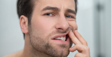 Man checking his teeth and looking disturbed